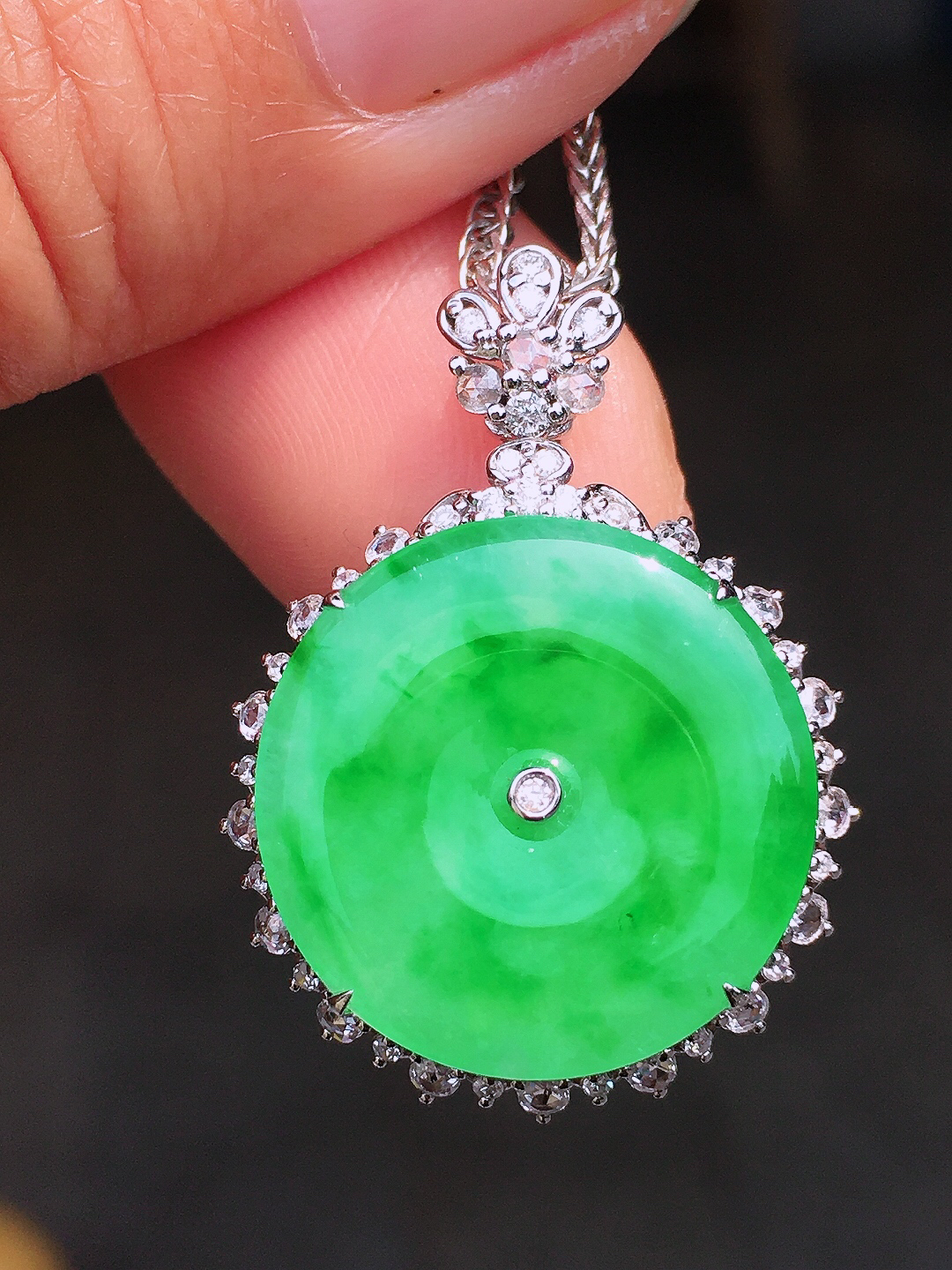 阳绿平安扣吊坠，色泽均匀艳丽，玉质细腻，荧光感超
强，饱满圆润，尽显优雅气质，18k
金豪华镶嵌