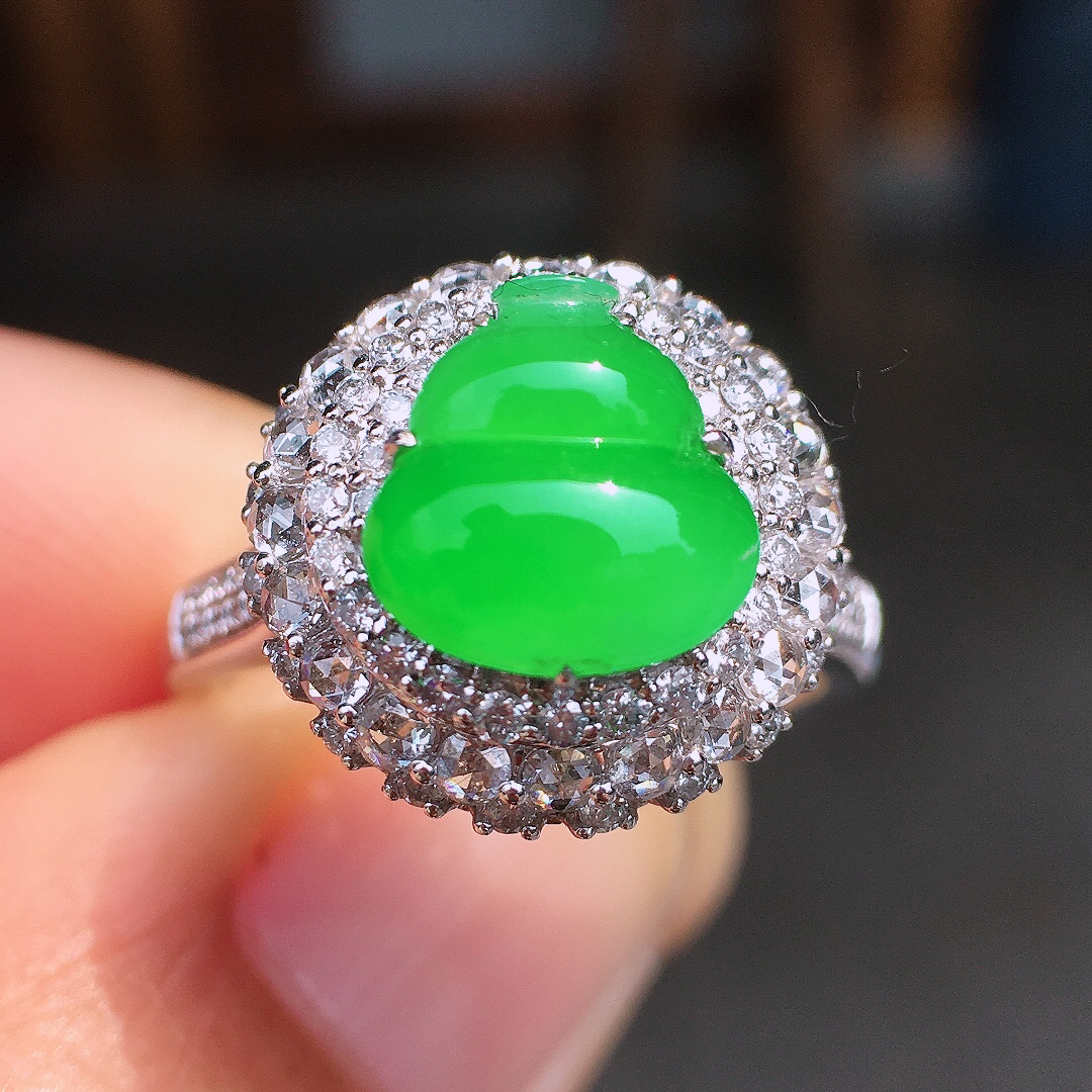 阳绿葫芦戒指，色泽均匀艳丽，玉质细腻，荧光感超
强，饱满圆润，尽显优雅气质，18k
金豪华镶嵌