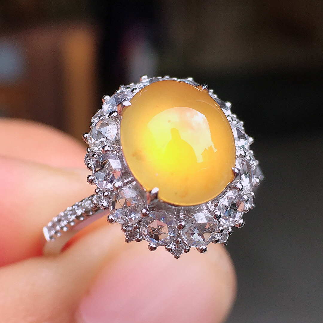 黄翡蛋面戒指，色泽均匀艳丽，玉质细腻，荧光感超
强，饱满圆润，尽显优雅气质，18k
金豪华镶嵌