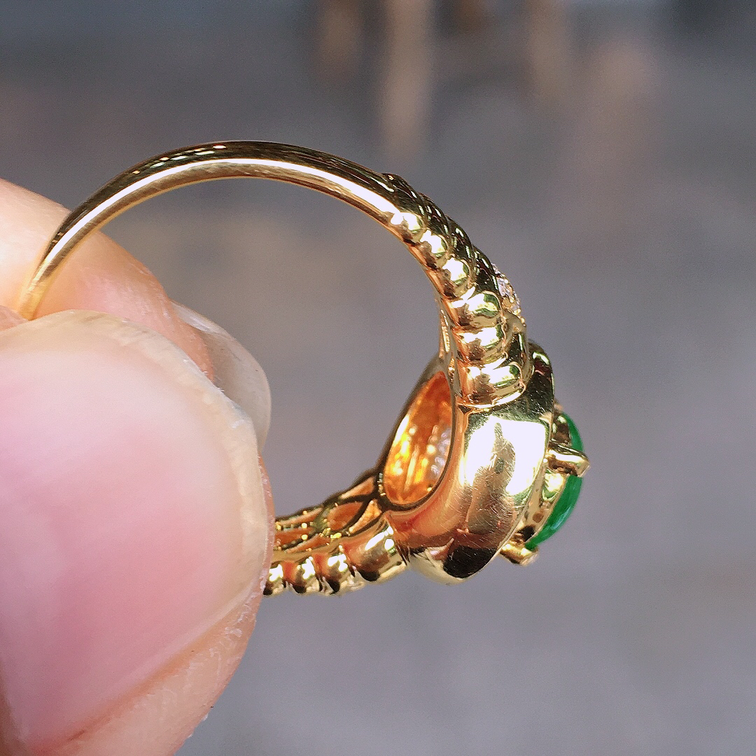 阳绿蛋面戒指，色泽均匀艳丽，玉质细腻，荧光感超
强，饱满圆润，尽显优雅气质，18k
金豪华镶嵌