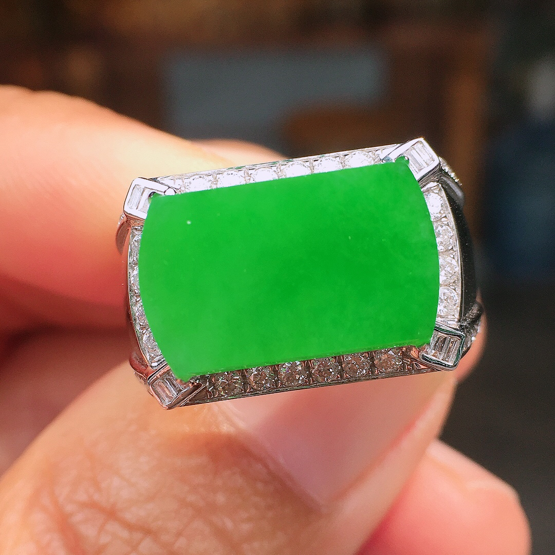 阳绿马鞍戒指，色泽均匀艳丽，玉质细腻，荧光感超
强，饱满圆润，尽显优雅气质，18k
金豪华镶嵌