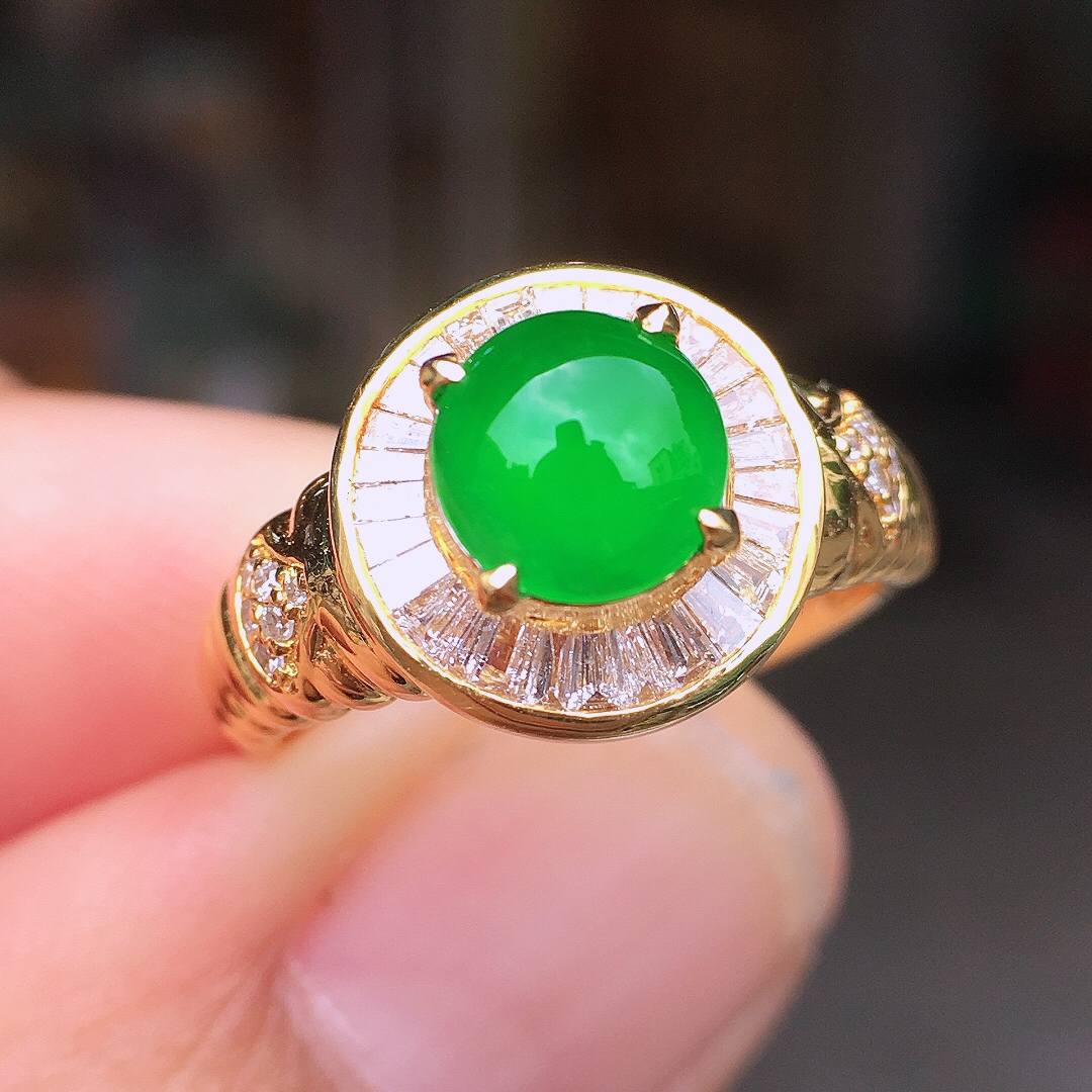 阳绿蛋面戒指，色泽均匀艳丽，玉质细腻，荧光感超
强，饱满圆润，尽显优雅气质，18k
金豪华镶嵌