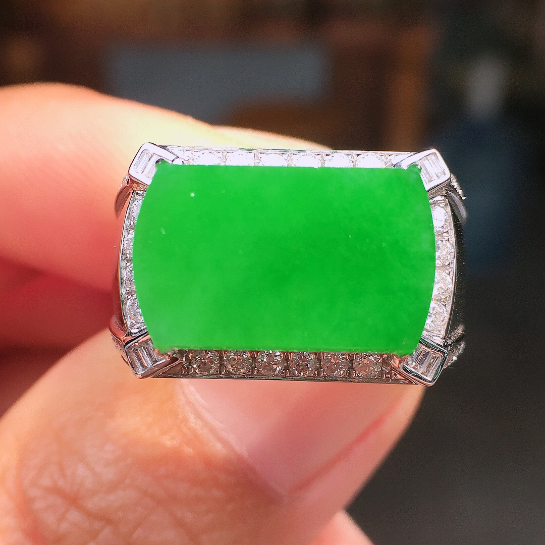 阳绿马鞍戒指，色泽均匀艳丽，玉质细腻，荧光感超
强，饱满圆润，尽显优雅气质，18k
金豪华镶嵌