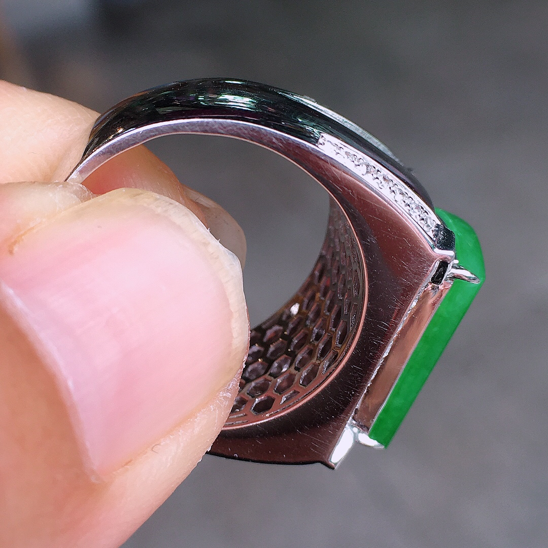 阳绿马鞍戒指，色泽均匀艳丽，玉质细腻，荧光感超
强，饱满圆润，尽显优雅气质，18k
金豪华镶嵌