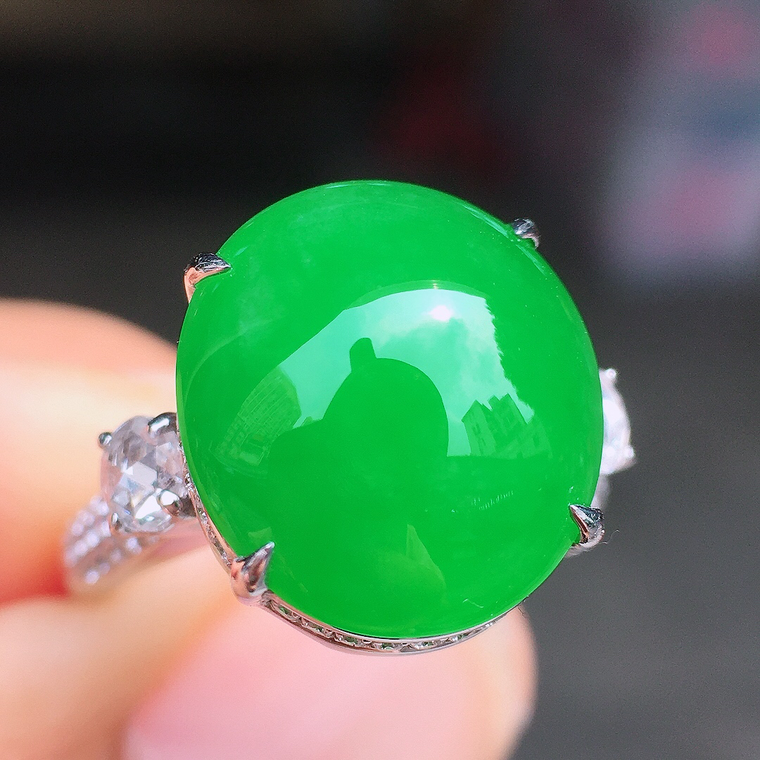 阳绿蛋面戒指，色泽均匀艳丽，玉质细腻，荧光感超
强，饱满圆润，尽显优雅气质，18k
金豪华镶嵌