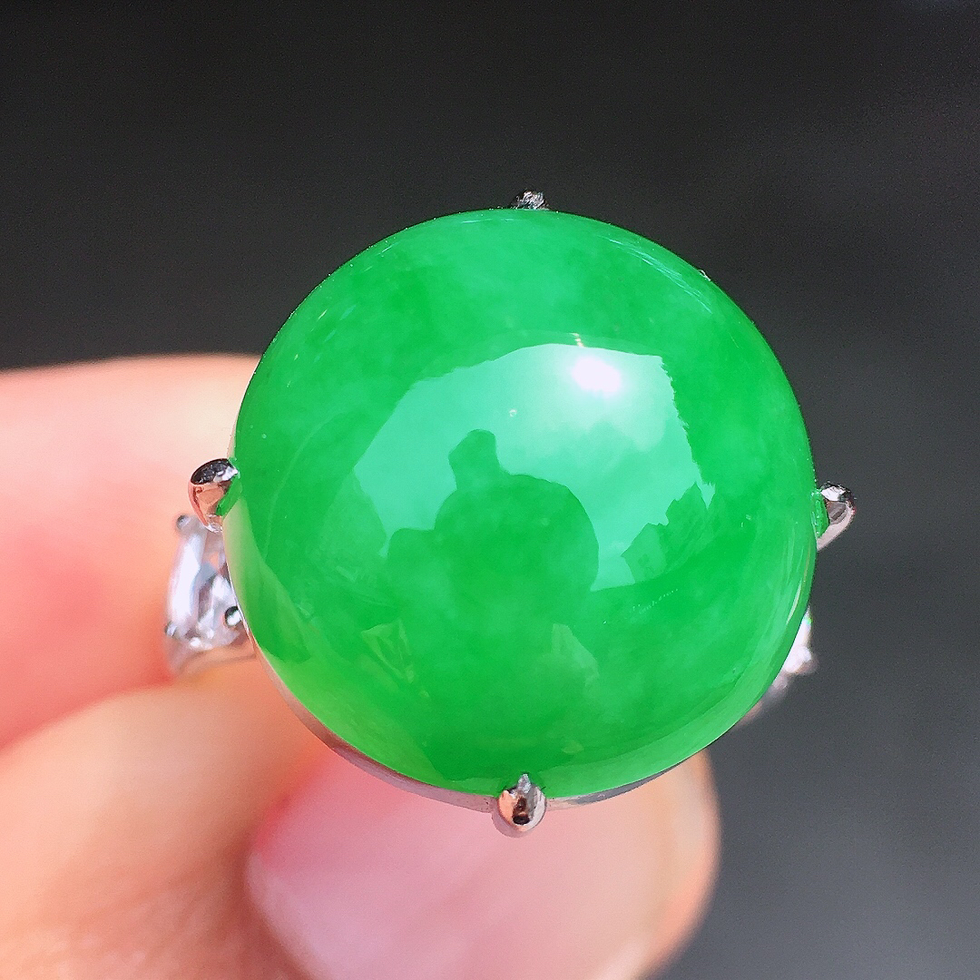 阳绿蛋面戒指，色泽均匀艳丽，玉质细腻，荧光感超
强，饱满圆润，尽显优雅气质，18k
金豪华镶嵌