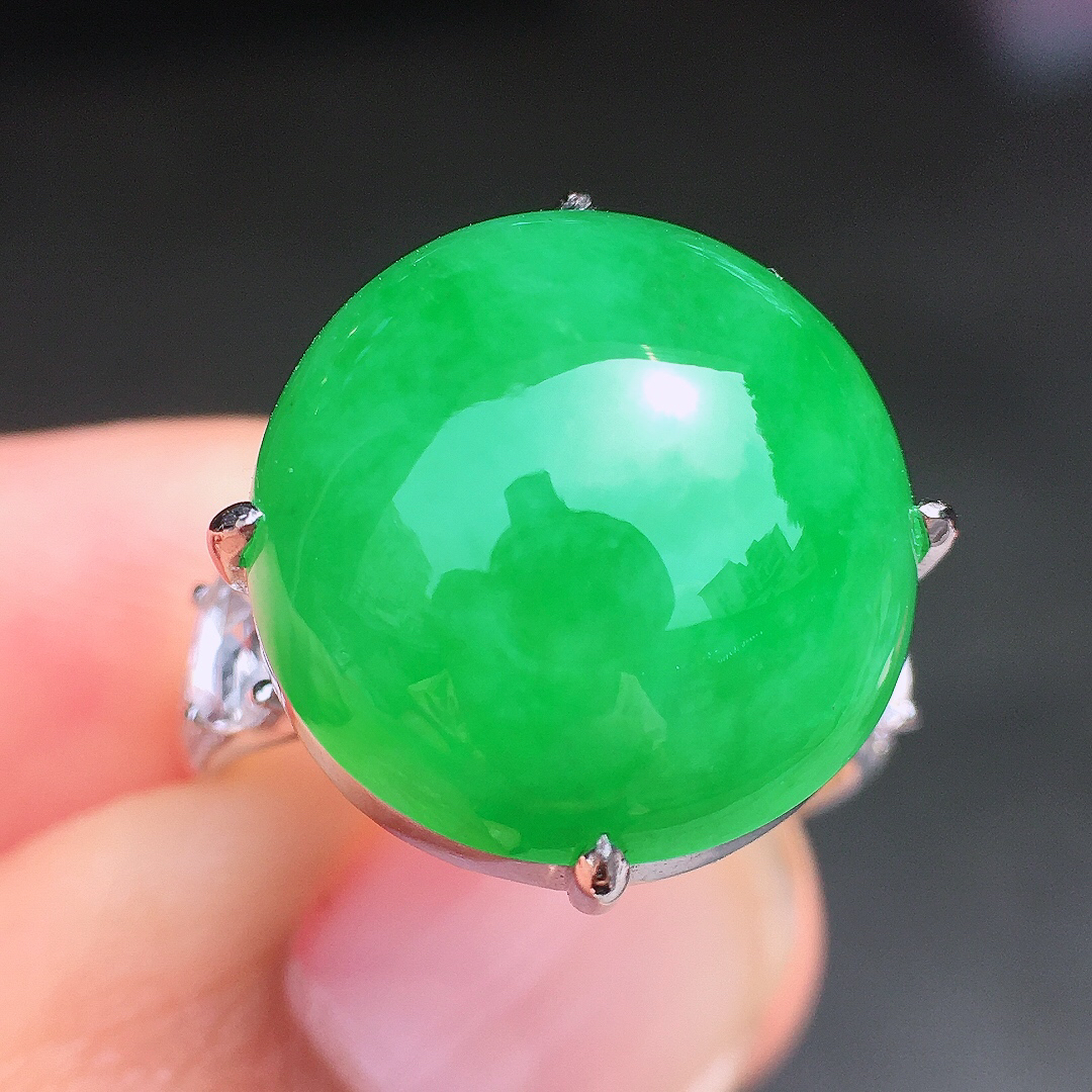 阳绿蛋面戒指，色泽均匀艳丽，玉质细腻，荧光感超
强，饱满圆润，尽显优雅气质，18k
金豪华镶嵌