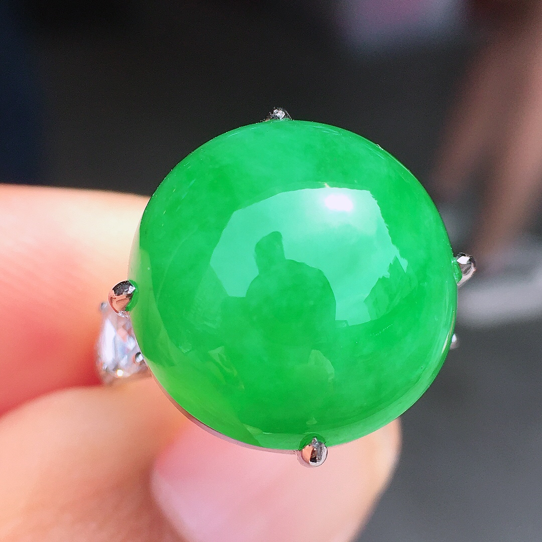 阳绿蛋面戒指，色泽均匀艳丽，玉质细腻，荧光感超
强，饱满圆润，尽显优雅气质，18k
金豪华镶嵌