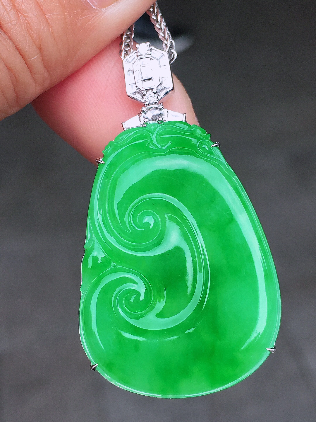 阳绿如意吊坠，色泽均匀艳丽，玉质细腻，荧光感超
强，饱满圆润，尽显优雅气质，18k
金豪华镶嵌