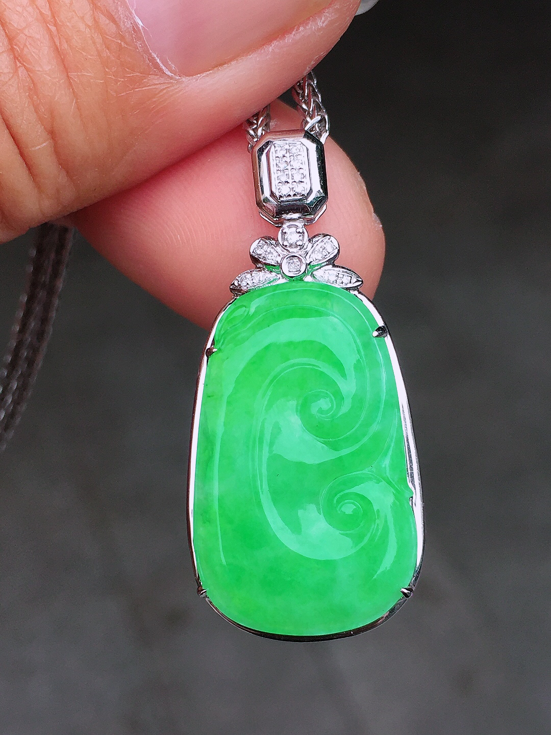 阳绿如意吊坠，色泽均匀艳丽，玉质细腻，荧光感超
强，饱满圆润，尽显优雅气质，18k
金豪华镶嵌