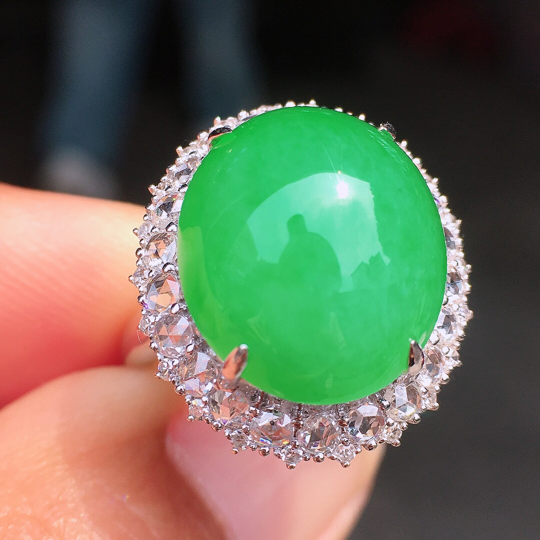 阳绿蛋面戒指，色泽均匀艳丽，玉质细腻，荧光感超
强，饱满圆润，尽显优雅气质，18k
金豪华镶嵌
