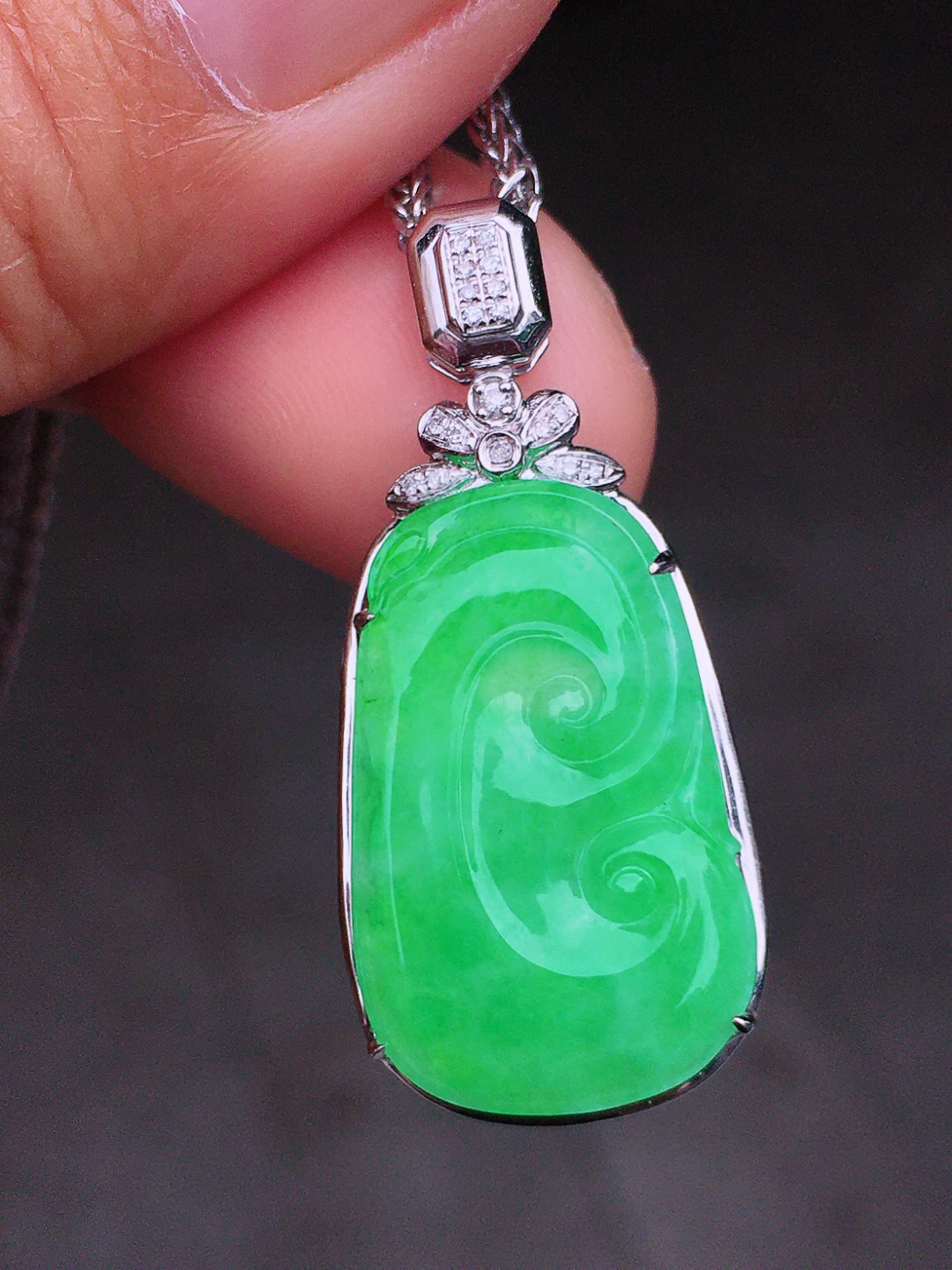 阳绿如意吊坠，色泽均匀艳丽，玉质细腻，荧光感超
强，饱满圆润，尽显优雅气质，18k
金豪华镶嵌