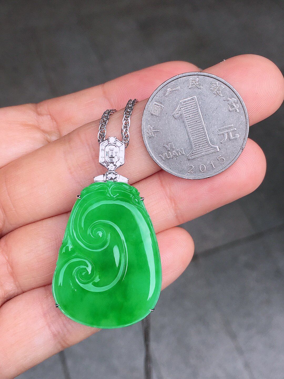 阳绿如意吊坠，色泽均匀艳丽，玉质细腻，荧光感超
强，饱满圆润，尽显优雅气质，18k
金豪华镶嵌