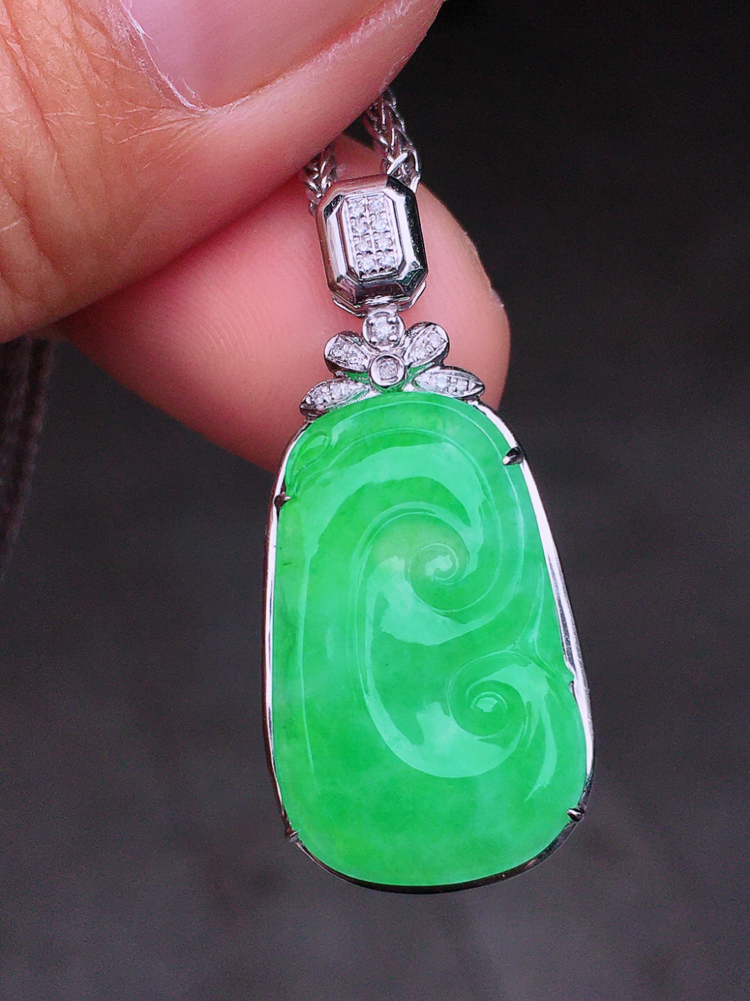 阳绿如意吊坠，色泽均匀艳丽，玉质细腻，荧光感超
强，饱满圆润，尽显优雅气质，18k
金豪华镶嵌