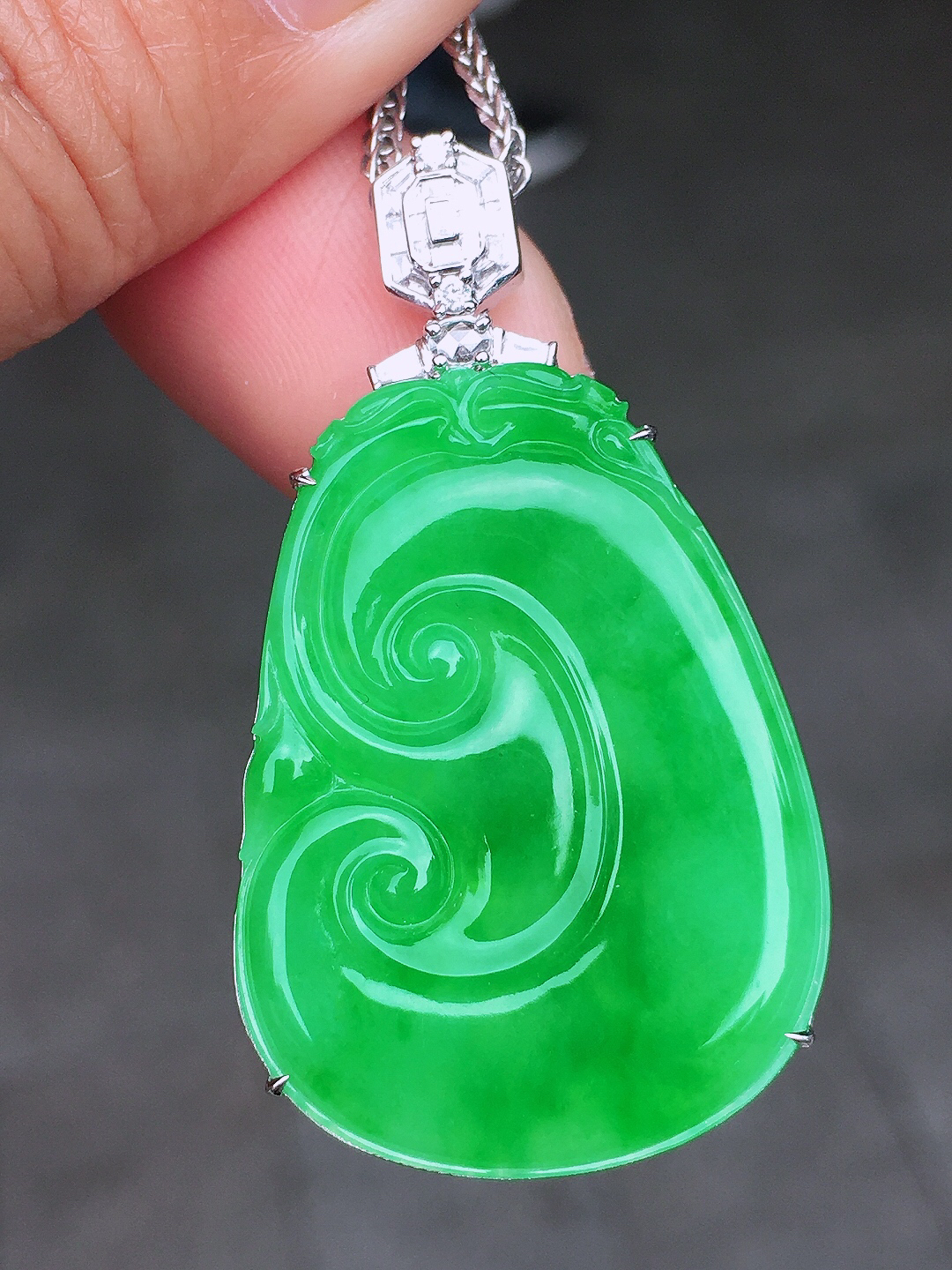 阳绿如意吊坠，色泽均匀艳丽，玉质细腻，荧光感超
强，饱满圆润，尽显优雅气质，18k
金豪华镶嵌