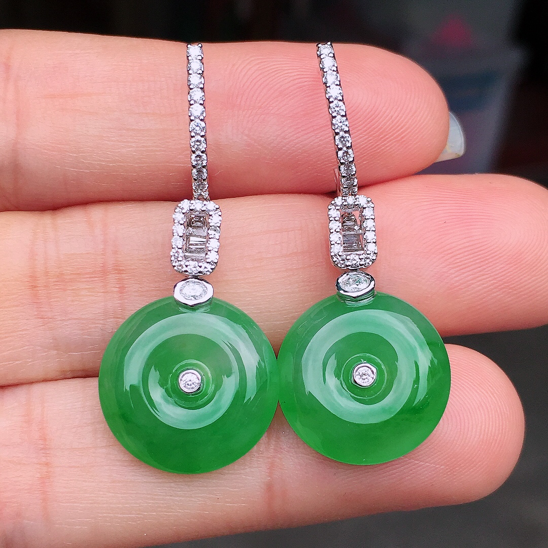 阳绿平安扣耳坠，色泽均匀艳丽，玉质细腻，荧光感超
强，饱满圆润，尽显优雅气质，18k
金豪华镶嵌