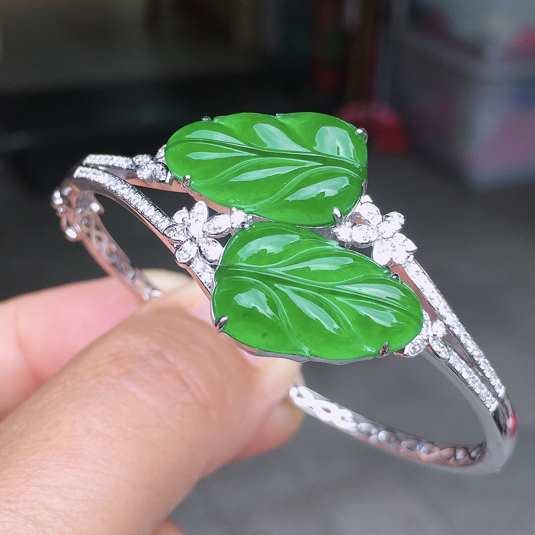 阳绿玉叶手镯，色泽均匀艳丽，玉质细腻，荧光感超
强，饱满圆润，尽显优雅气质，18k
金豪华镶嵌