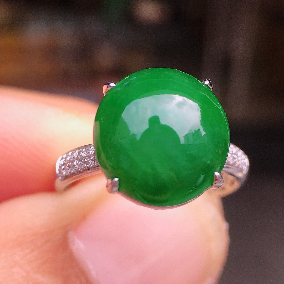 阳绿蛋面戒指，色泽均匀艳丽，玉质细腻，荧光感超
强，饱满圆润，尽显优雅气质，18k
金豪华镶嵌