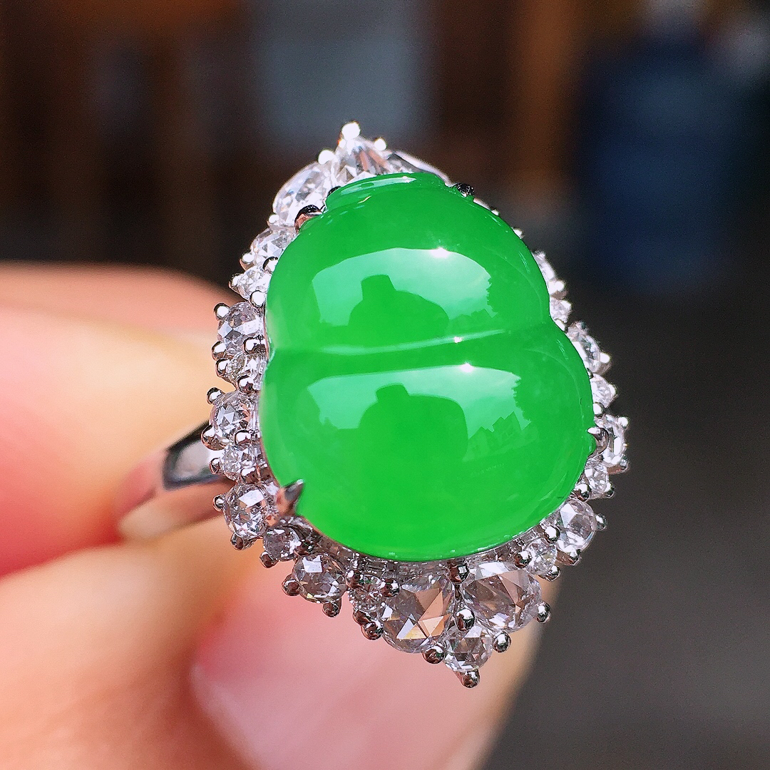 阳绿葫芦戒指，色泽均匀艳丽，玉质细腻，荧光感超
强，饱满圆润，尽显优雅气质，18k
金豪华镶嵌