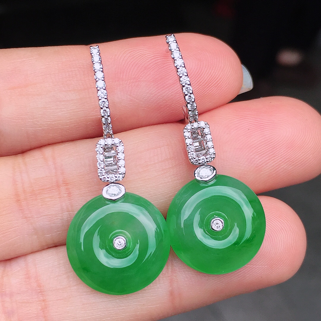 阳绿平安扣耳坠，色泽均匀艳丽，玉质细腻，荧光感超
强，饱满圆润，尽显优雅气质，18k
金豪华镶嵌