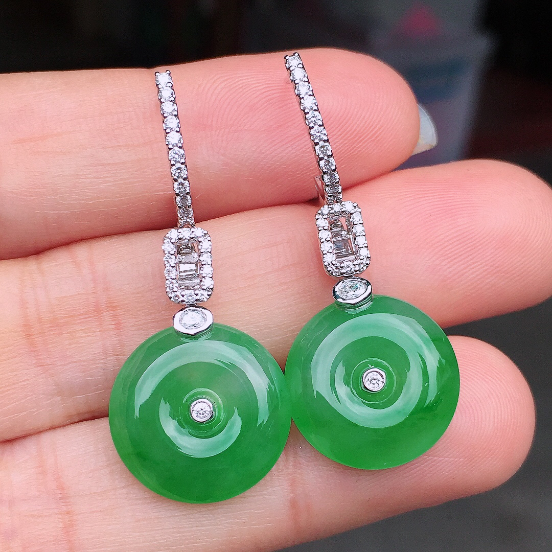 阳绿平安扣耳坠，色泽均匀艳丽，玉质细腻，荧光感超
强，饱满圆润，尽显优雅气质，18k
金豪华镶嵌