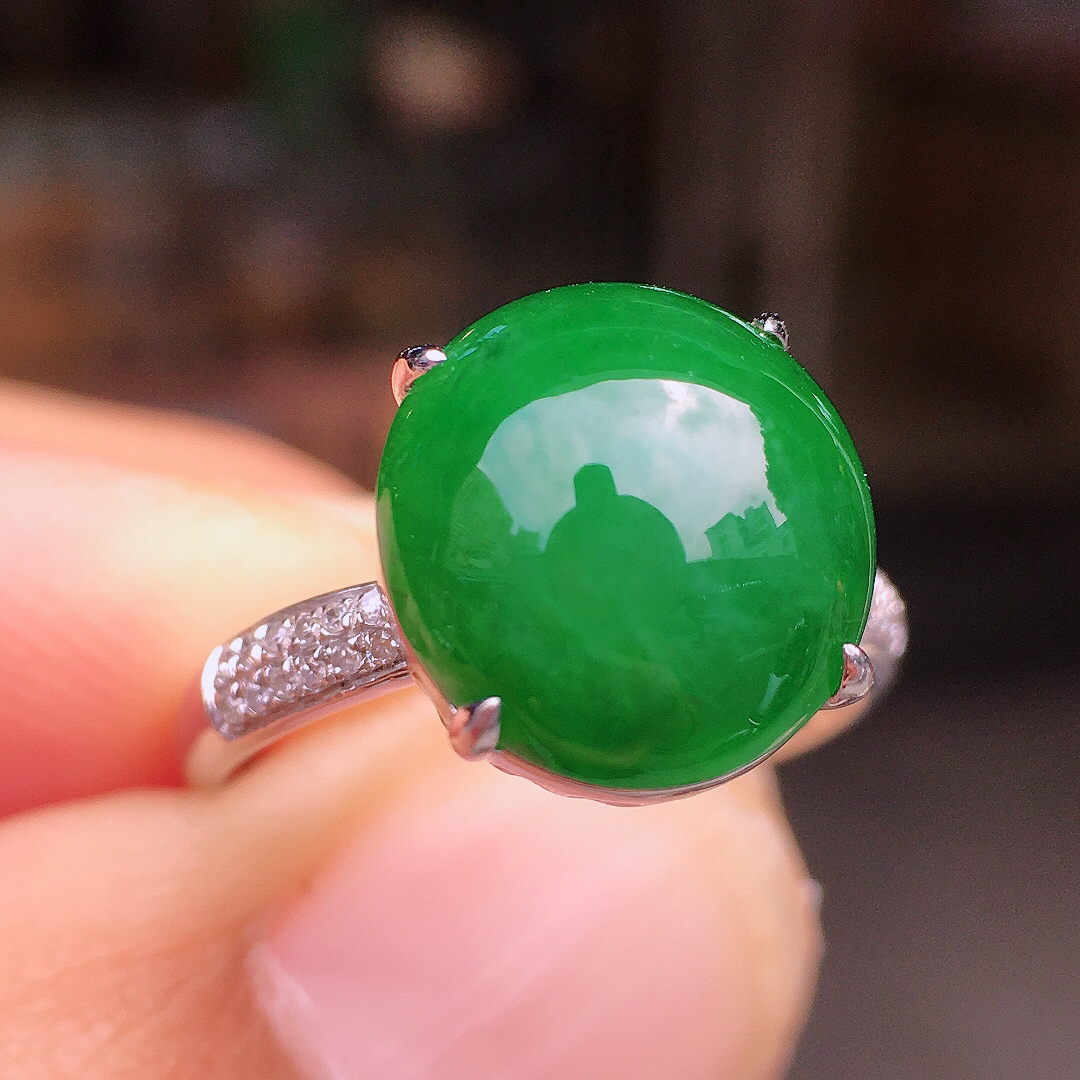 阳绿蛋面戒指，色泽均匀艳丽，玉质细腻，荧光感超
强，饱满圆润，尽显优雅气质，18k
金豪华镶嵌