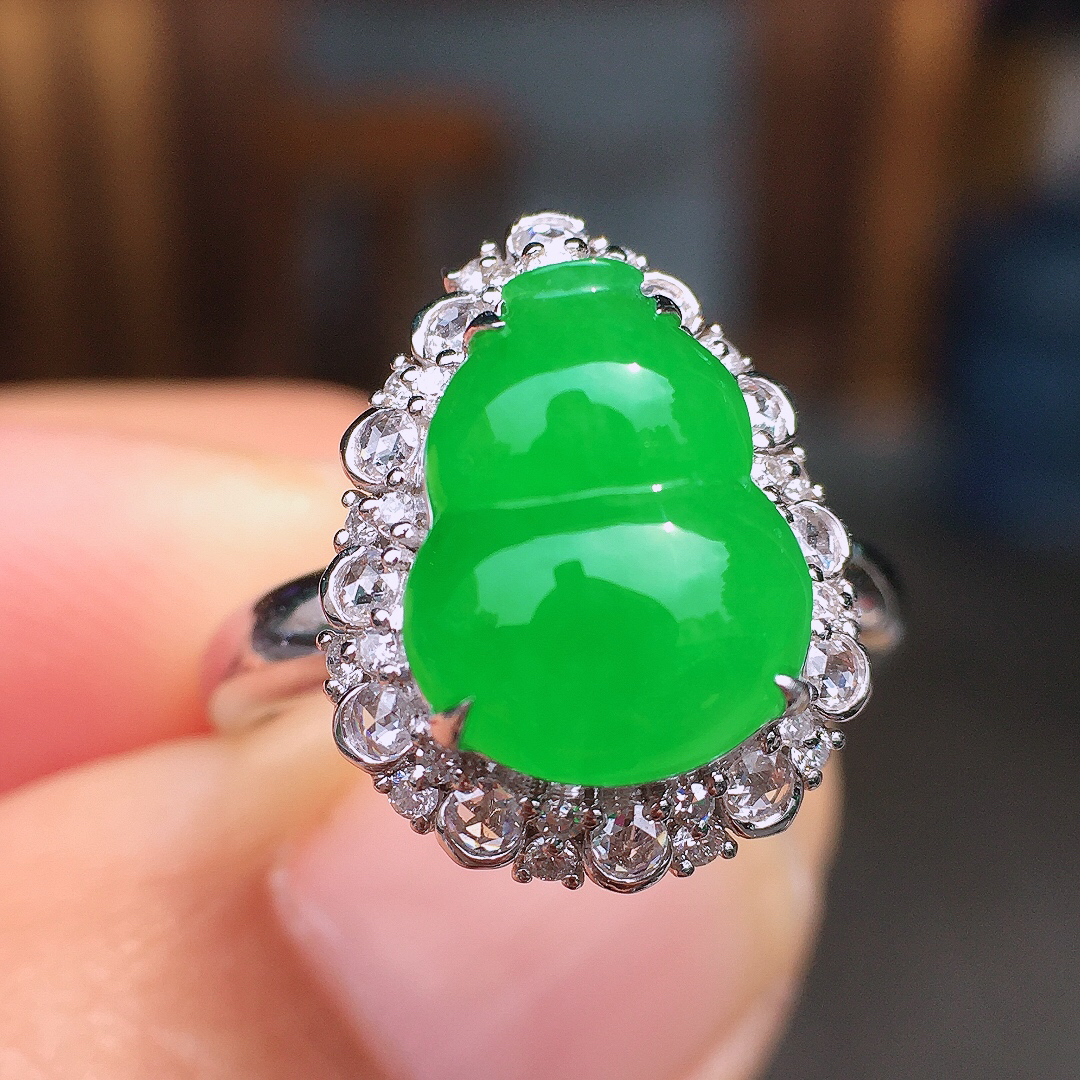 阳绿葫芦戒指，色泽均匀艳丽，玉质细腻，荧光感超
强，饱满圆润，尽显优雅气质，18k
金豪华镶嵌