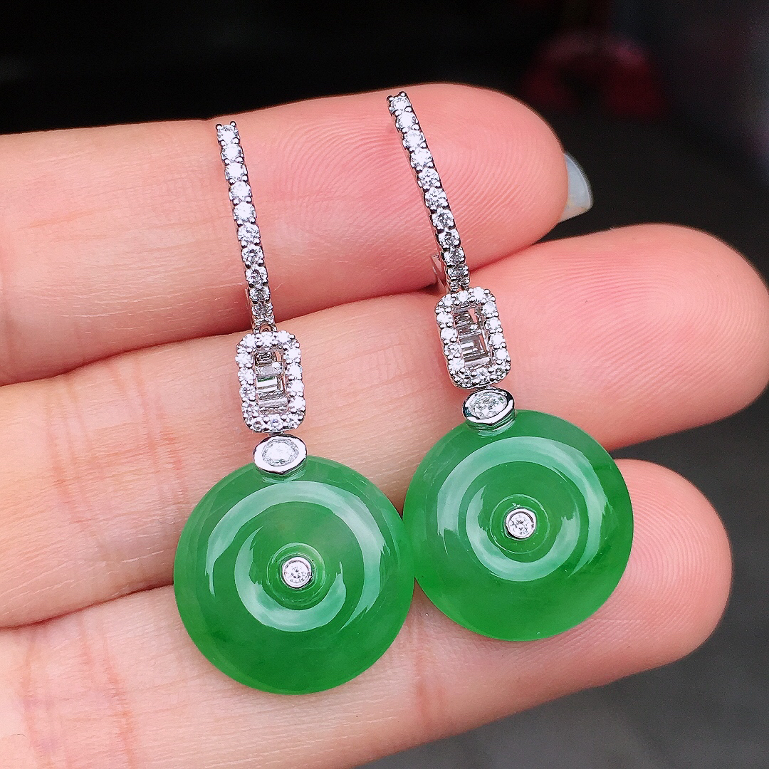 阳绿平安扣耳坠，色泽均匀艳丽，玉质细腻，荧光感超
强，饱满圆润，尽显优雅气质，18k
金豪华镶嵌