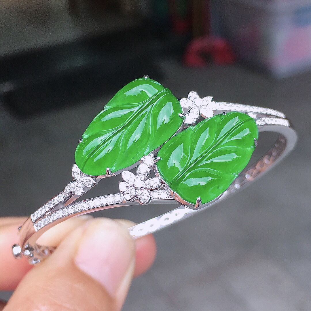 阳绿玉叶手镯，色泽均匀艳丽，玉质细腻，荧光感超
强，饱满圆润，尽显优雅气质，18k
金豪华镶嵌