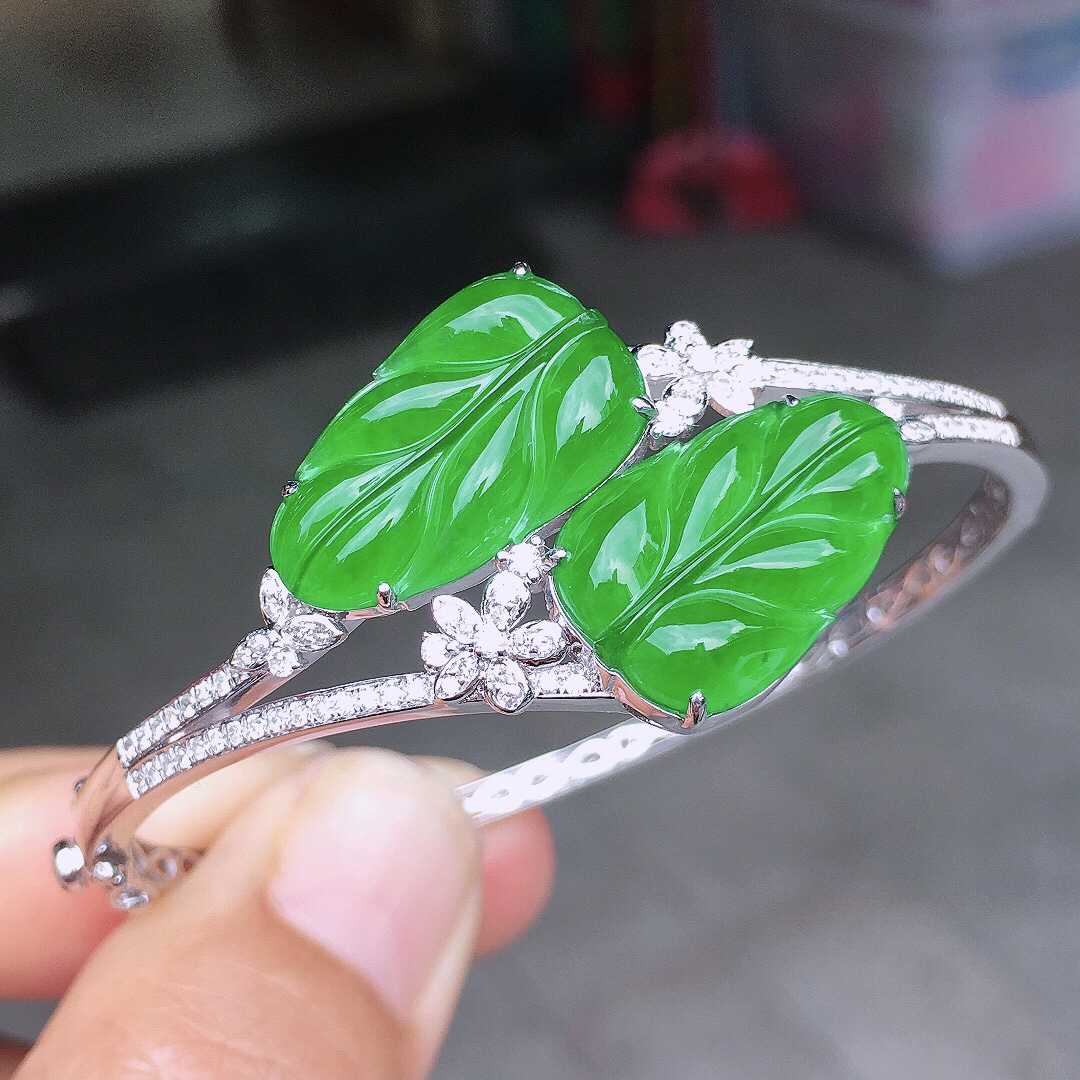 阳绿玉叶手镯，色泽均匀艳丽，玉质细腻，荧光感超
强，饱满圆润，尽显优雅气质，18k
金豪华镶嵌