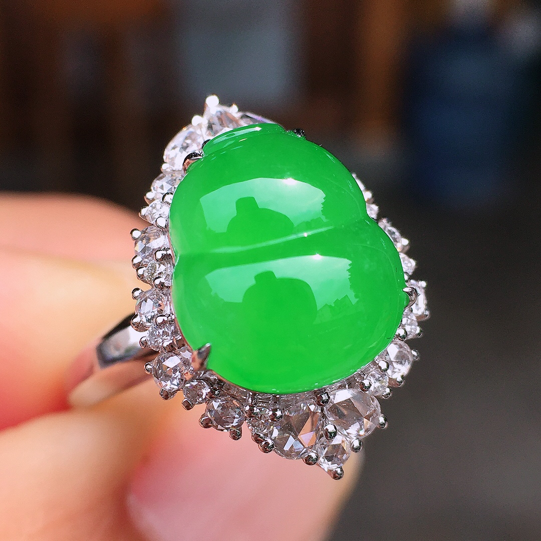 阳绿葫芦戒指，色泽均匀艳丽，玉质细腻，荧光感超
强，饱满圆润，尽显优雅气质，18k
金豪华镶嵌