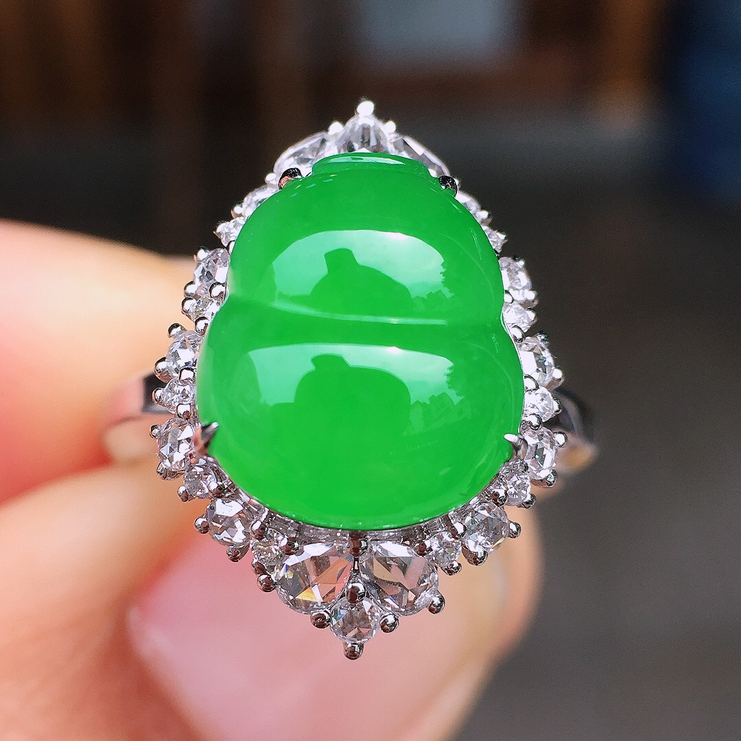 阳绿葫芦戒指，色泽均匀艳丽，玉质细腻，荧光感超
强，饱满圆润，尽显优雅气质，18k
金豪华镶嵌