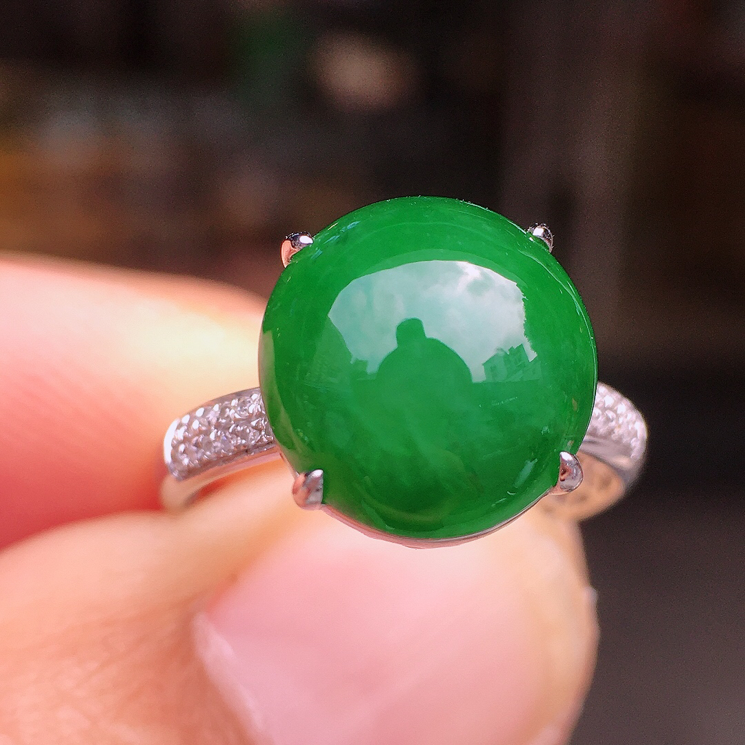 阳绿蛋面戒指，色泽均匀艳丽，玉质细腻，荧光感超
强，饱满圆润，尽显优雅气质，18k
金豪华镶嵌