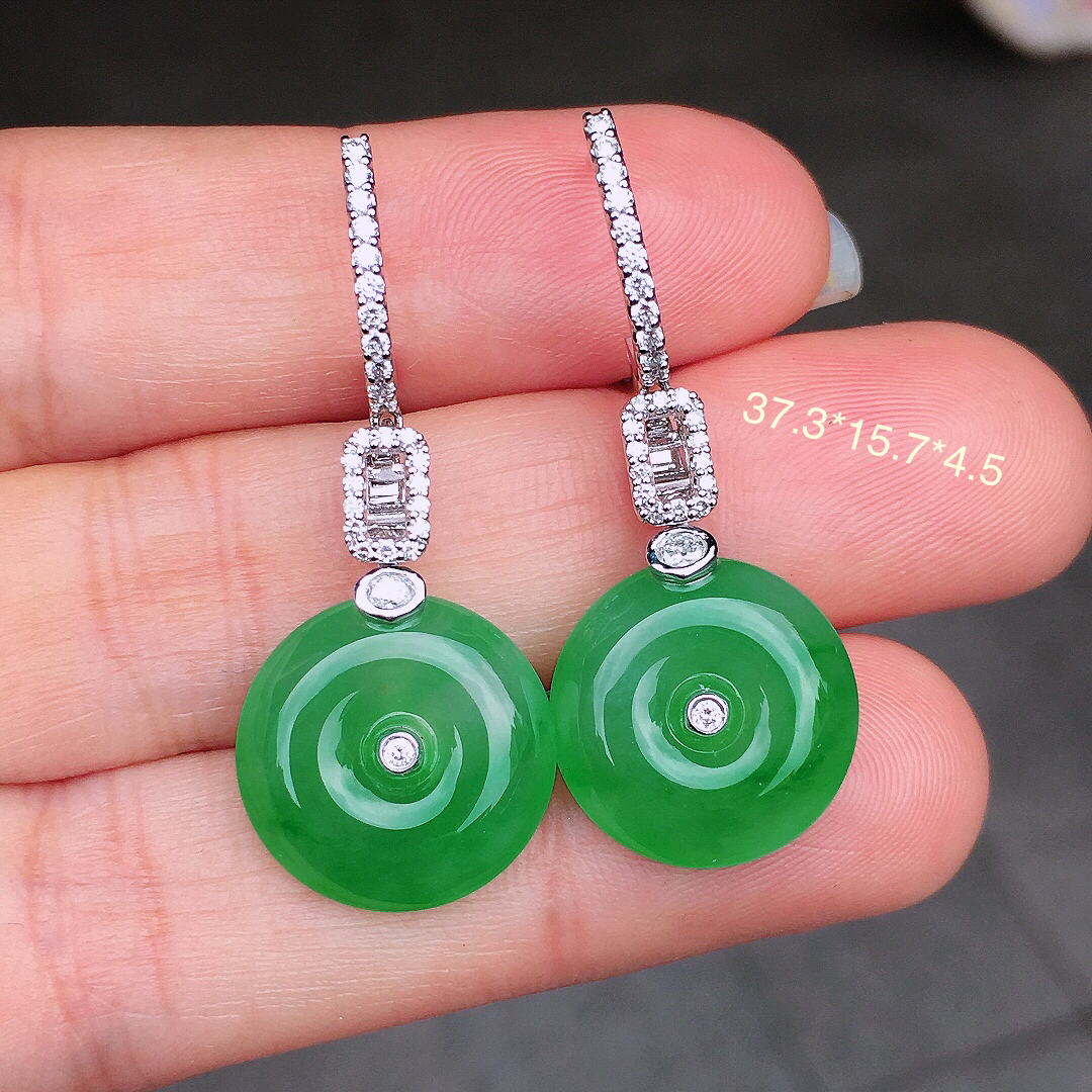 阳绿平安扣耳坠，色泽均匀艳丽，玉质细腻，荧光感超
强，饱满圆润，尽显优雅气质，18k
金豪华镶嵌