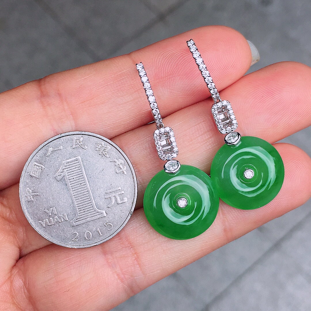 阳绿平安扣耳坠，色泽均匀艳丽，玉质细腻，荧光感超
强，饱满圆润，尽显优雅气质，18k
金豪华镶嵌