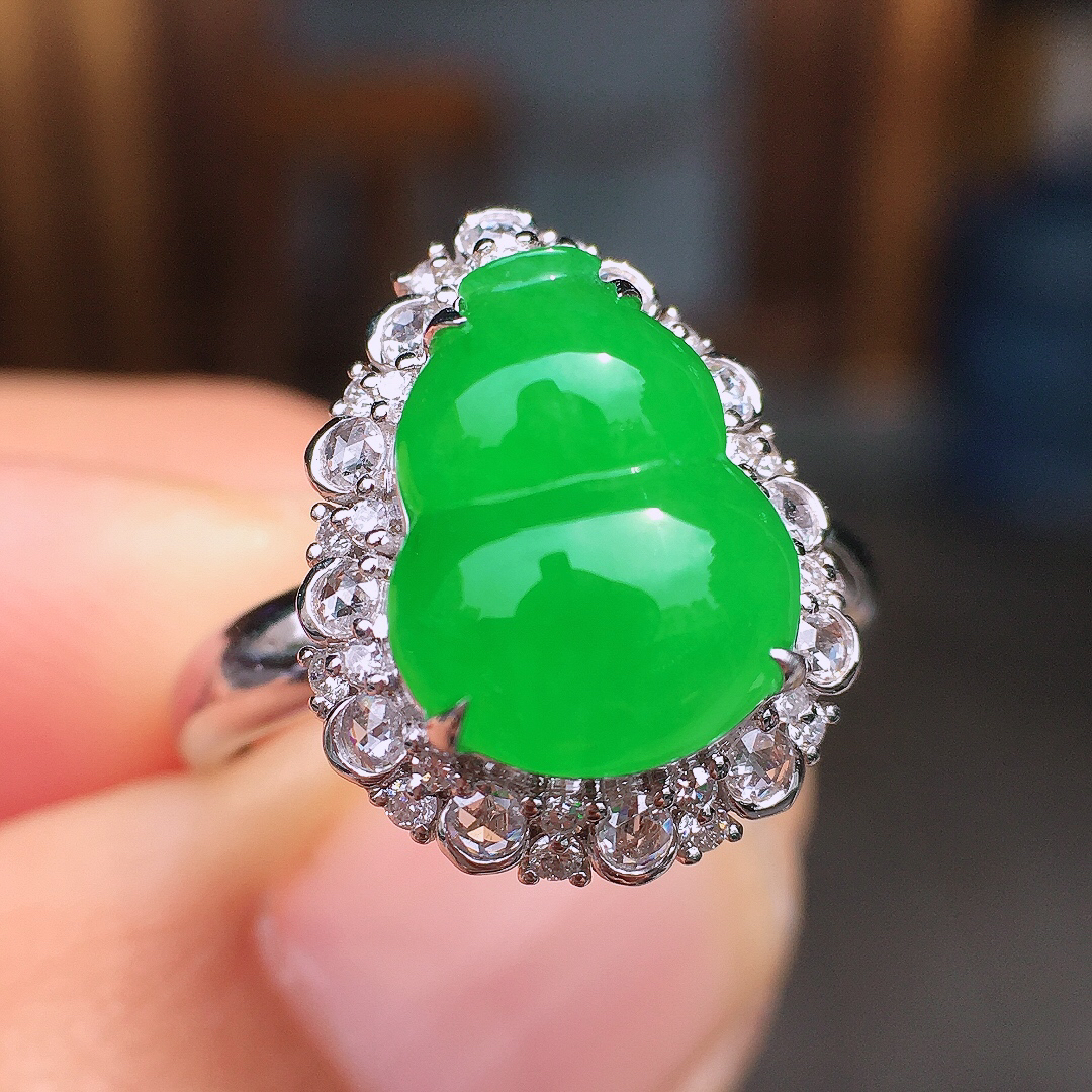 阳绿葫芦戒指，色泽均匀艳丽，玉质细腻，荧光感超
强，饱满圆润，尽显优雅气质，18k
金豪华镶嵌