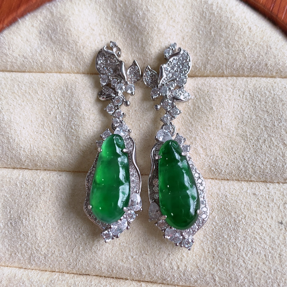 冰满绿翡翠925银镶嵌福豆耳钉，自然光实拍，翠色灵动，颜色漂亮，种老水足，品相佳，佩戴佳品！W502.28  取一整体尺寸：36.5-10.2-6.3mm  裸石尺寸：14.8-6.6mm