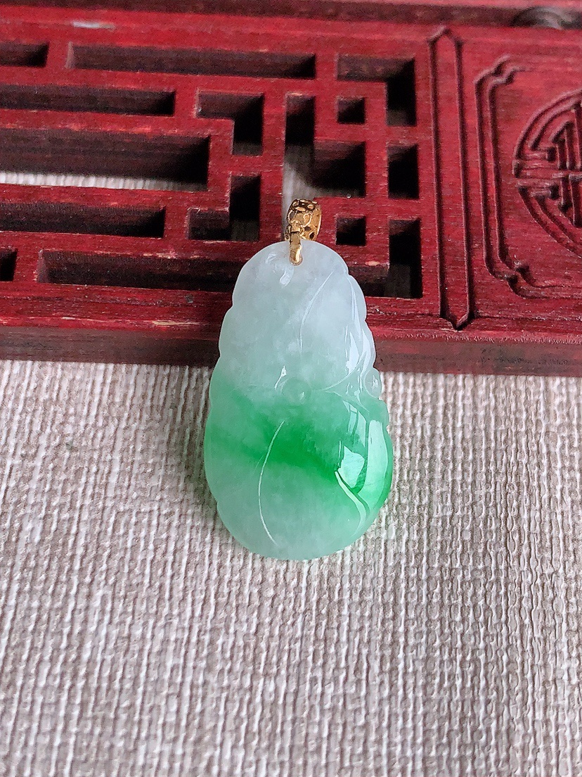 天然A货翡翠18K金扣头飘阳绿荷叶和和美美吊坠 
尺寸23.5-14-5.6mm 重量3.46g 0