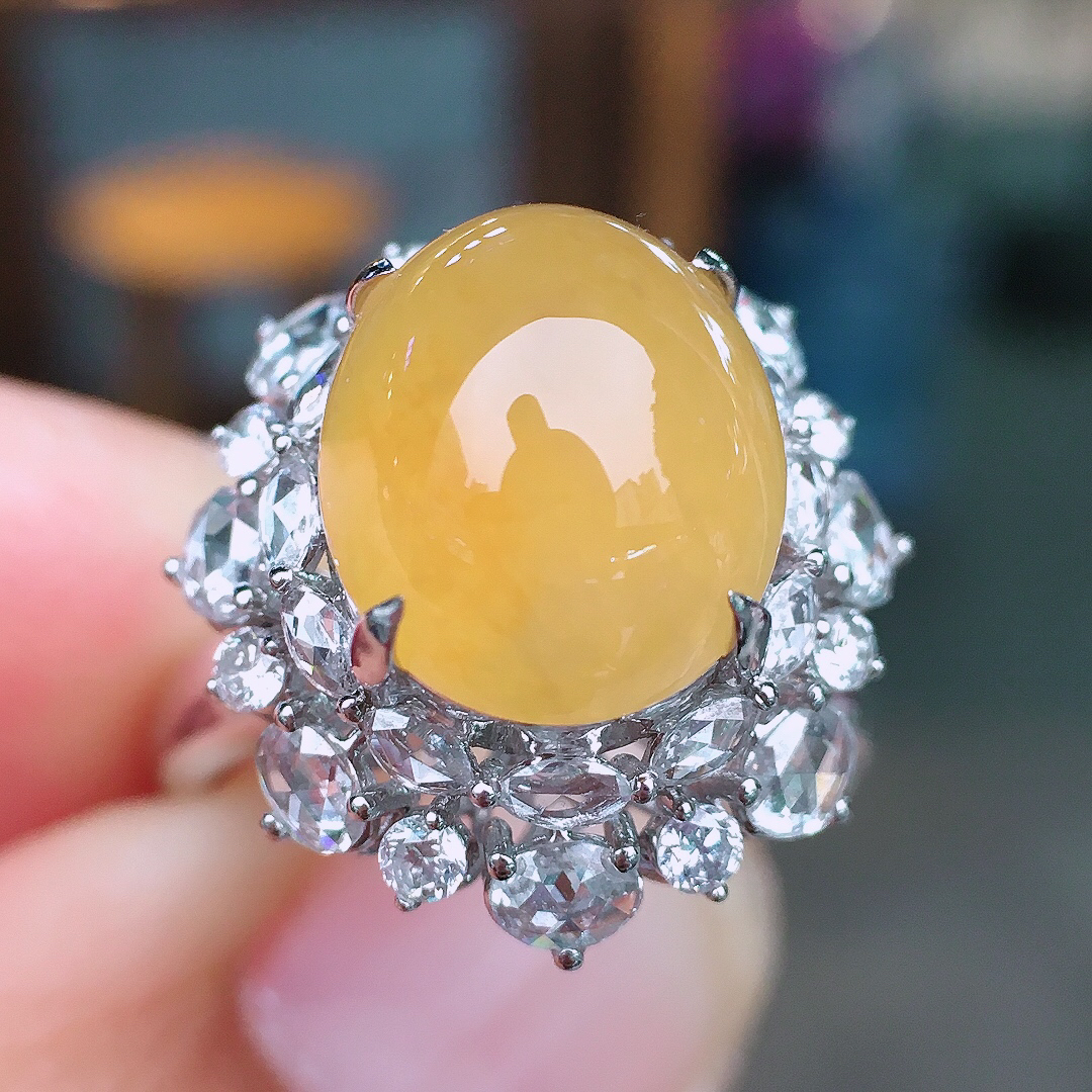 黄翡蛋面戒指，色泽均匀艳丽，玉质细腻，荧光感超
强，饱满圆润，尽显优雅气质，18k
金豪华镶嵌