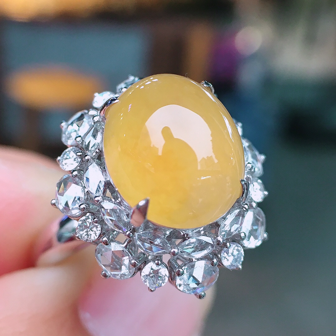 黄翡蛋面戒指，色泽均匀艳丽，玉质细腻，荧光感超
强，饱满圆润，尽显优雅气质，18k
金豪华镶嵌