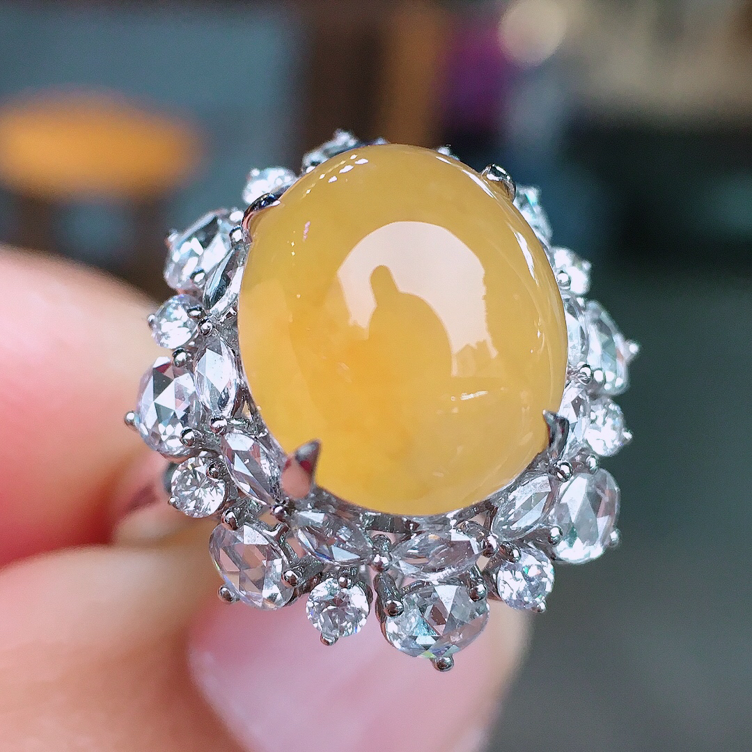 黄翡蛋面戒指，色泽均匀艳丽，玉质细腻，荧光感超
强，饱满圆润，尽显优雅气质，18k
金豪华镶嵌