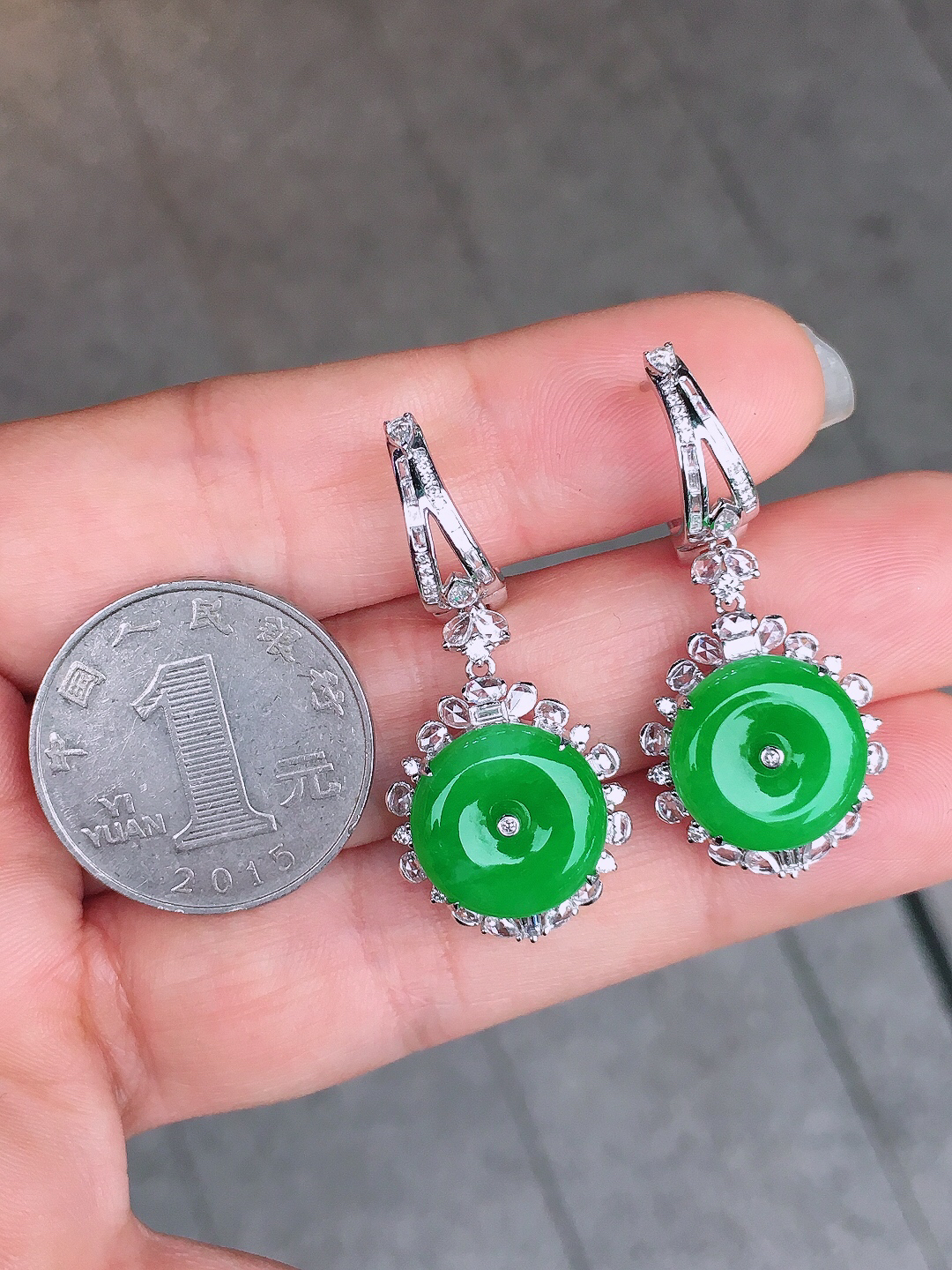 阳绿平安扣耳坠，色泽均匀艳丽，玉质细腻，荧光感超
强，饱满圆润，尽显优雅气质，18k
金豪华镶嵌