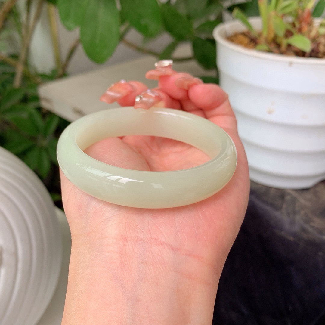 私人专拍超低价放漏，特批赠送手串一个
和田玉52.8圈口青白色手镯！重46.9克玉质细腻油润 底色纯净 无裂无杂 脂粉好，品质好！图为自然光拍摄