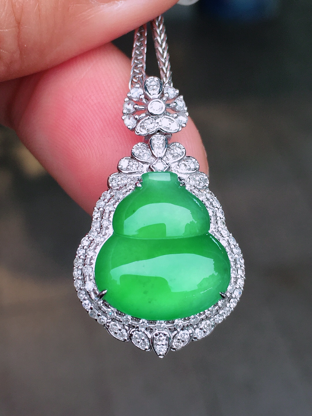 阳绿葫芦吊坠，色泽均匀艳丽，玉质细腻，荧光感超
强，饱满圆润，尽显优雅气质，18k
金豪华镶嵌