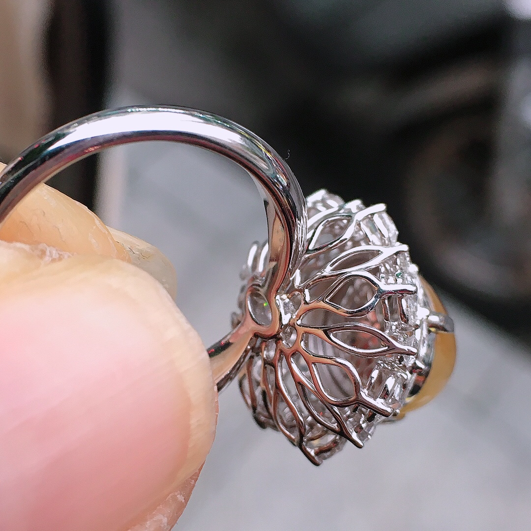 黄翡蛋面戒指，色泽均匀艳丽，玉质细腻，荧光感超
强，饱满圆润，尽显优雅气质，18k
金豪华镶嵌