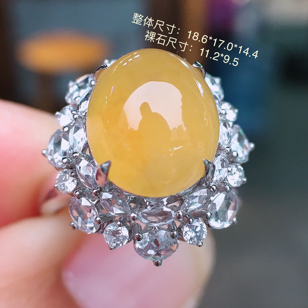 黄翡蛋面戒指，色泽均匀艳丽，玉质细腻，荧光感超
强，饱满圆润，尽显优雅气质，18k
金豪华镶嵌