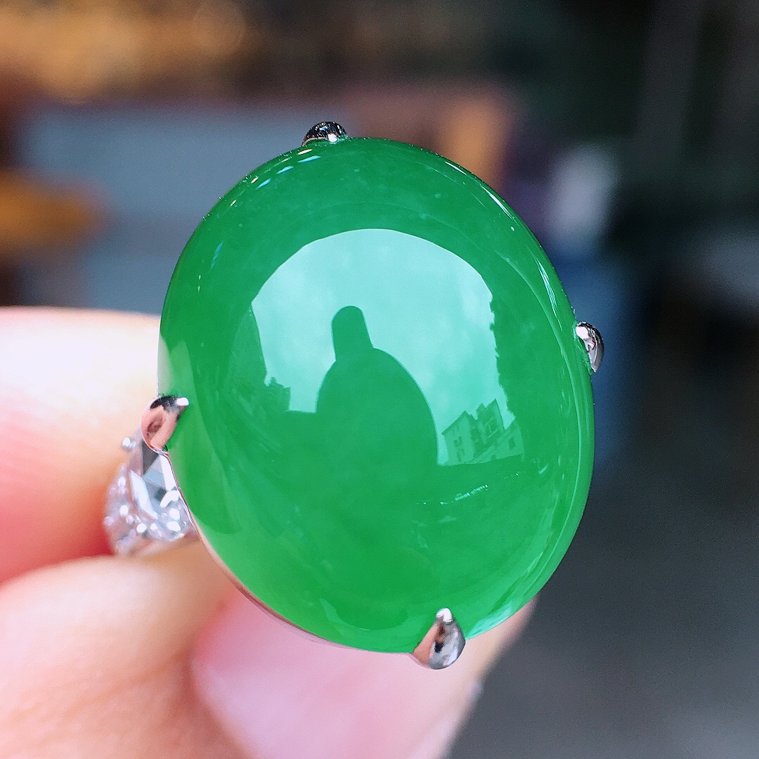 阳绿蛋面戒指，色泽均匀艳丽，玉质细腻，荧光感超
强，饱满圆润，尽显优雅气质，18k
金豪华镶嵌