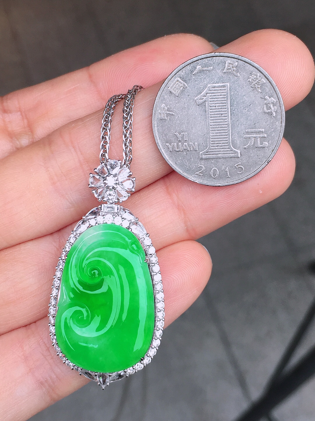 阳绿如意吊坠，色泽均匀艳丽，玉质细腻，荧光感超
强，饱满圆润，尽显优雅气质，18k
金豪华镶嵌