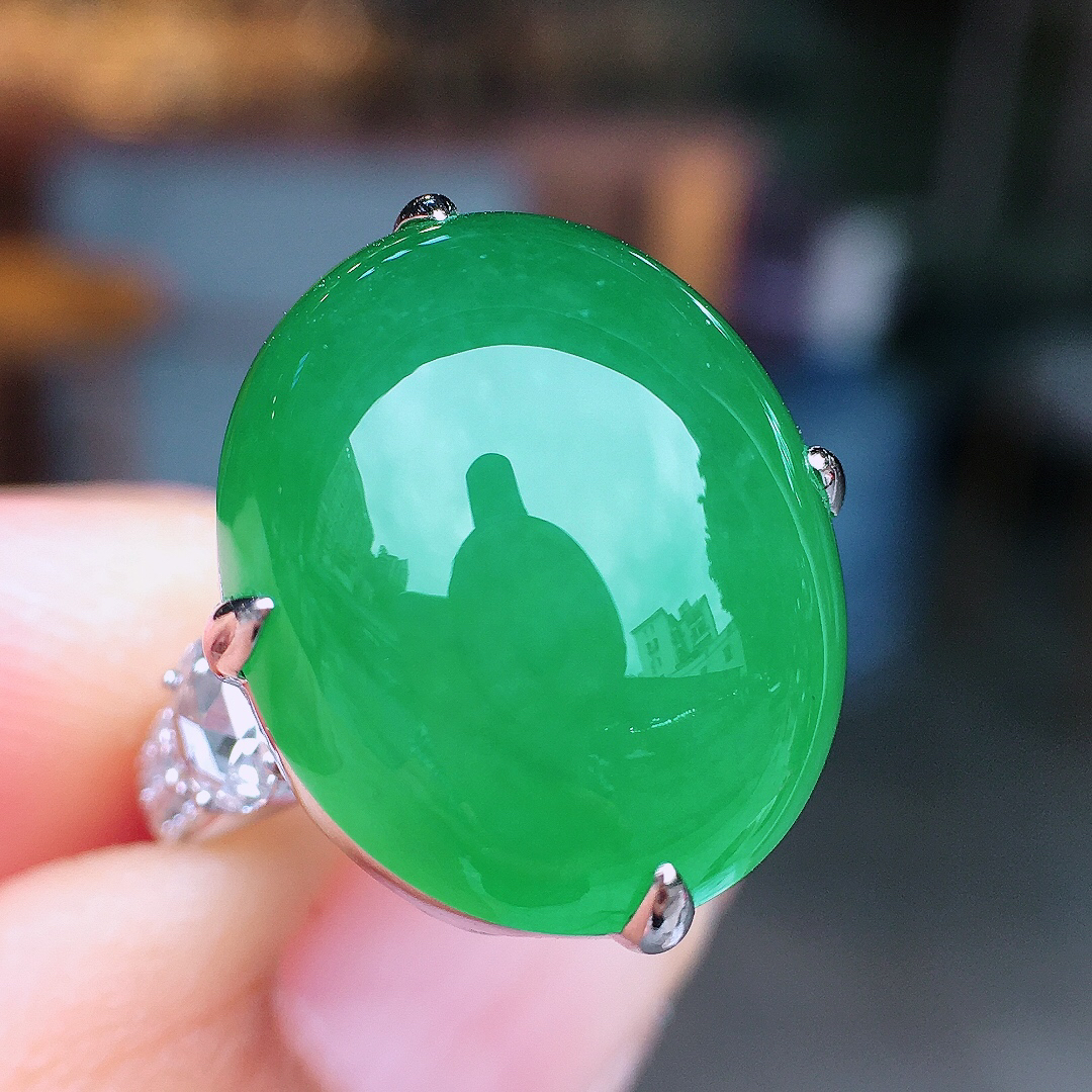 阳绿蛋面戒指，色泽均匀艳丽，玉质细腻，荧光感超
强，饱满圆润，尽显优雅气质，18k
金豪华镶嵌