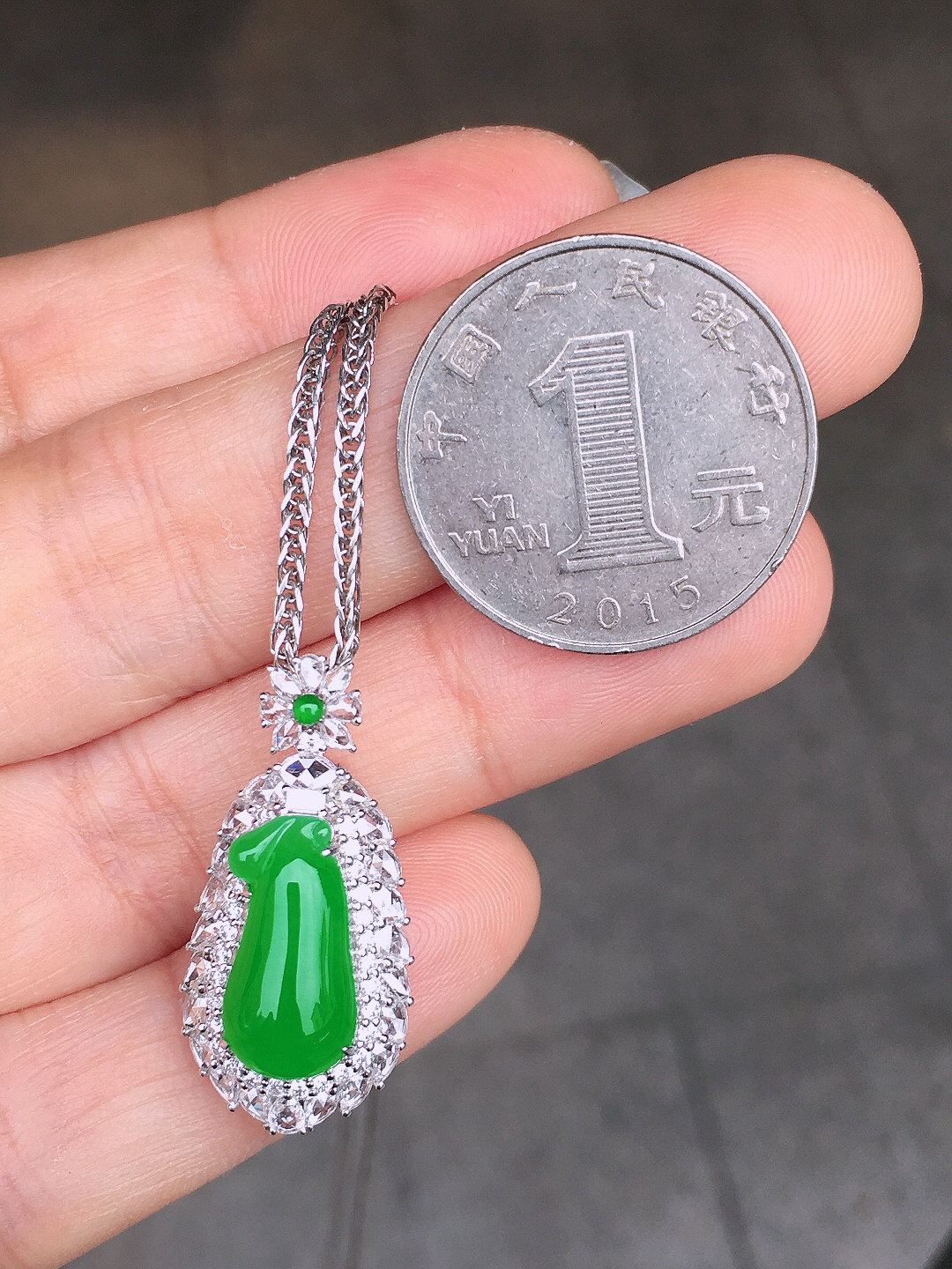 阳绿福瓜吊坠，色泽均匀艳丽，玉质细腻，荧光感超
强，饱满圆润，尽显优雅气质，18k
金豪华镶嵌